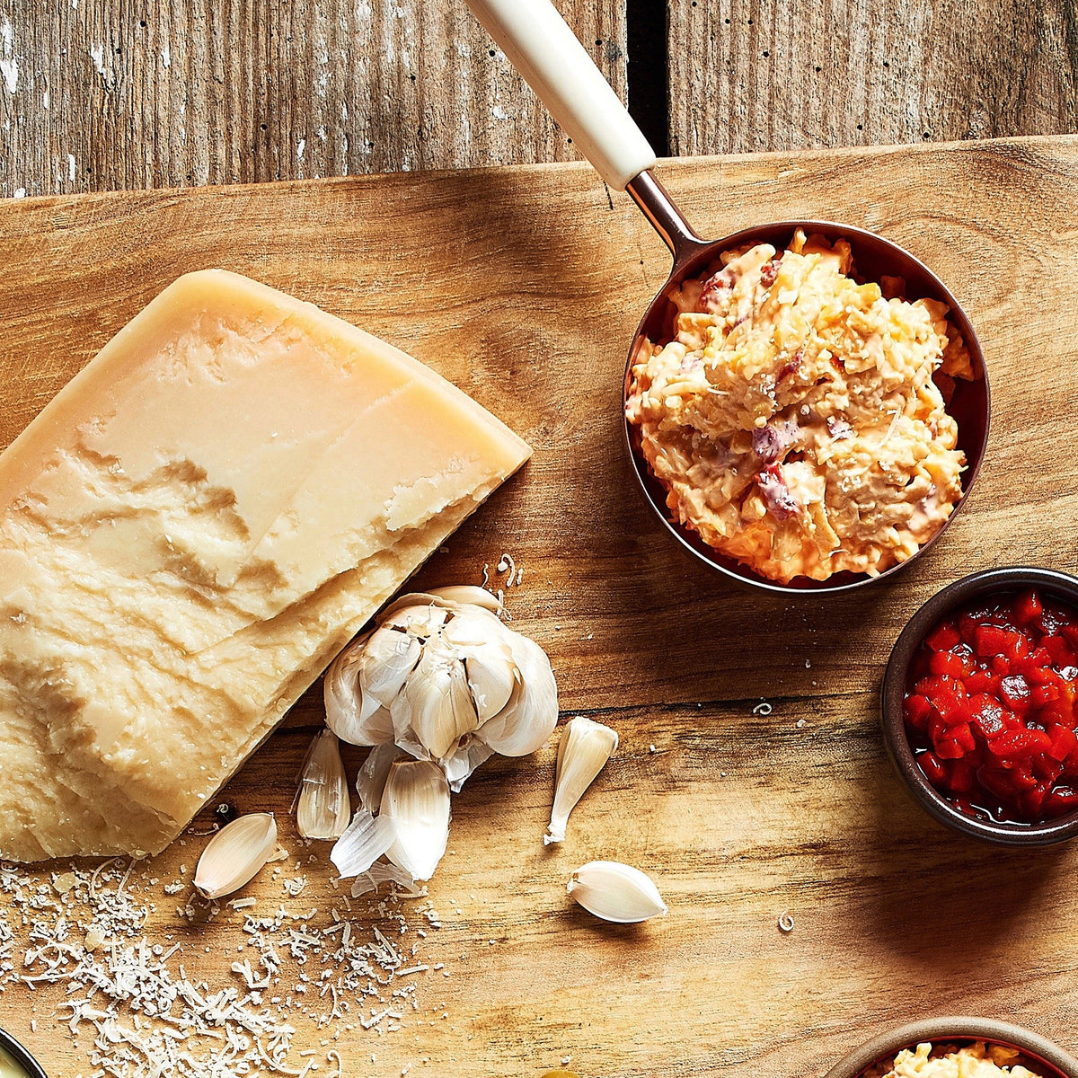 Birdie's Garlic Parmesan pimento cheese beside a wedge of Parmesan, garlic and diced pimentos