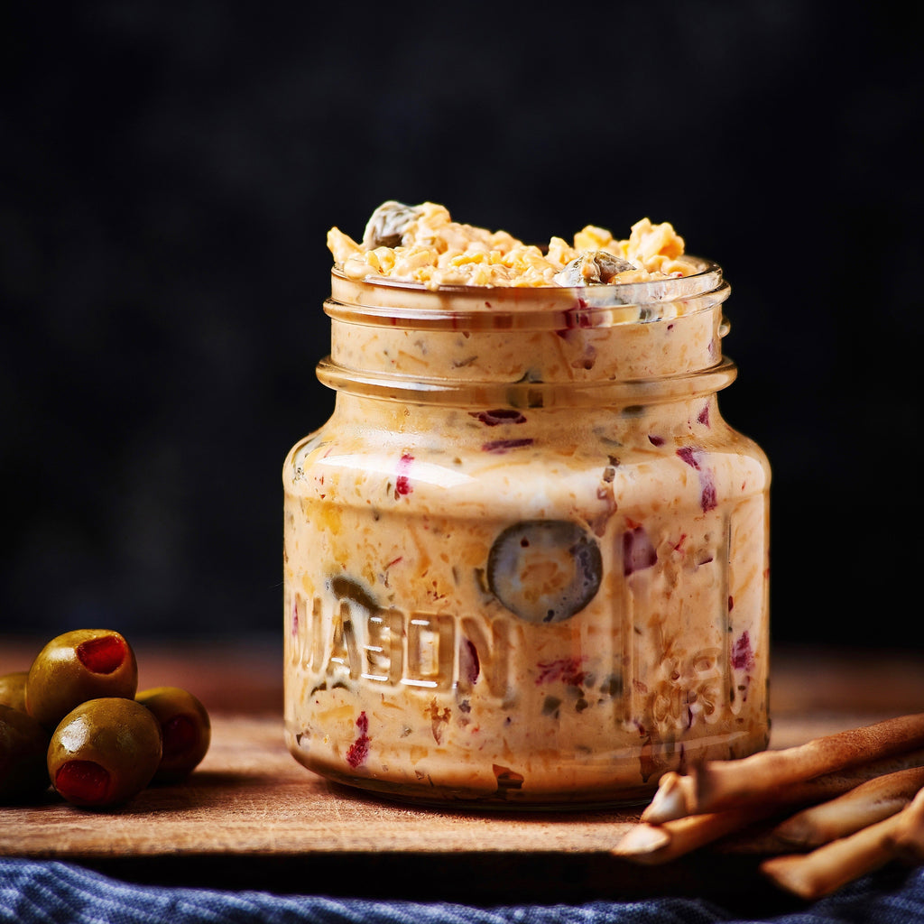Birdie's Olive pimento cheese in a mason jar with green olives